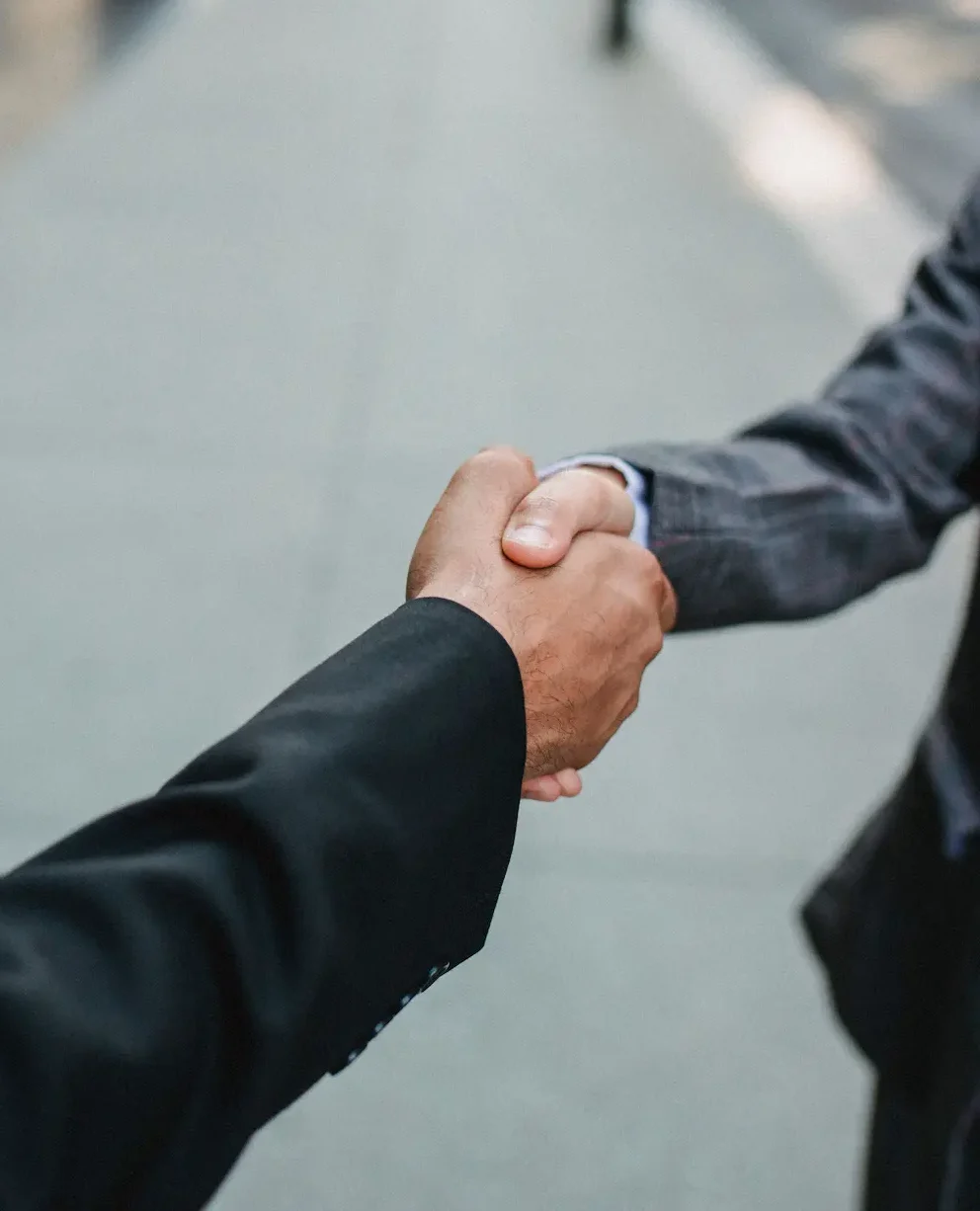 Close-up of a professional business handshake between two men in suits